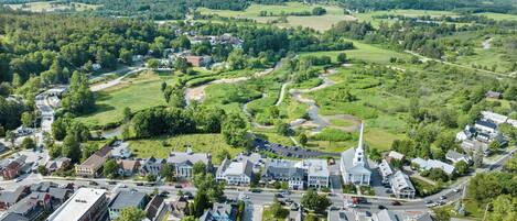 An aerial view of a town with a central church, surrounded by residential areas and green fields.