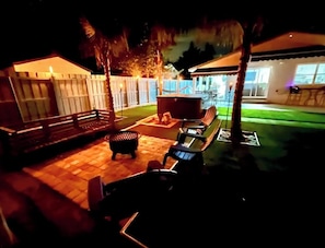 A patio area with outdoor seating, a hot tub, and a covered seating area.
