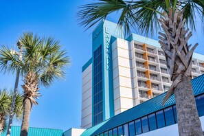 A multi-story hotel with a prominent 'Landmark' sign, balconies, and palm trees.