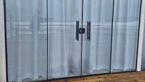 A room with a large, light-colored, semi-transparent curtain covering a sliding door. - Hibisco Guest House (Florianopolis)