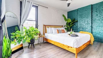 A modern bedroom with a wooden bed, a ceiling fan, and a large window.