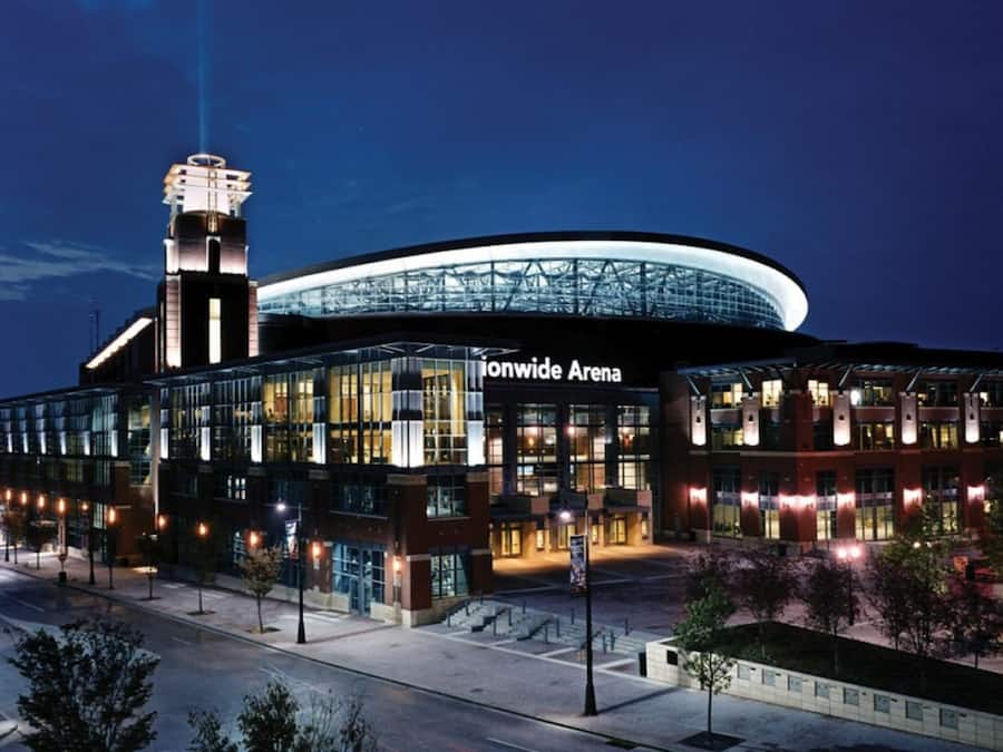 Un edificio moderno con una amplia fachada de vidrio y una torre destacada, identificada como 'Ionwide Arena'.
