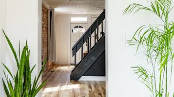 A wooden floor, a staircase, and a plant.