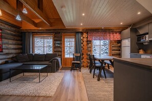 L’intérieur d’une cabane en rondins comprend un espace de vie, un coin repas et une cuisine.