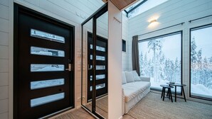 Un intérieur moderne avec un canapé et une petite table près de grandes fenêtres.