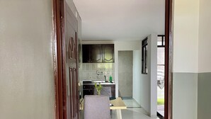 A doorway leading to a dining area with a table and chairs, a kitchen in the background, and a security camera on the wall. - Relax in Neiva: Modern apartment with bathtub close to Clinica Abner Lozano (Neiva)