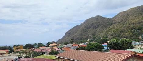 A residential area with houses featuring red roofs and a mountain in the background.