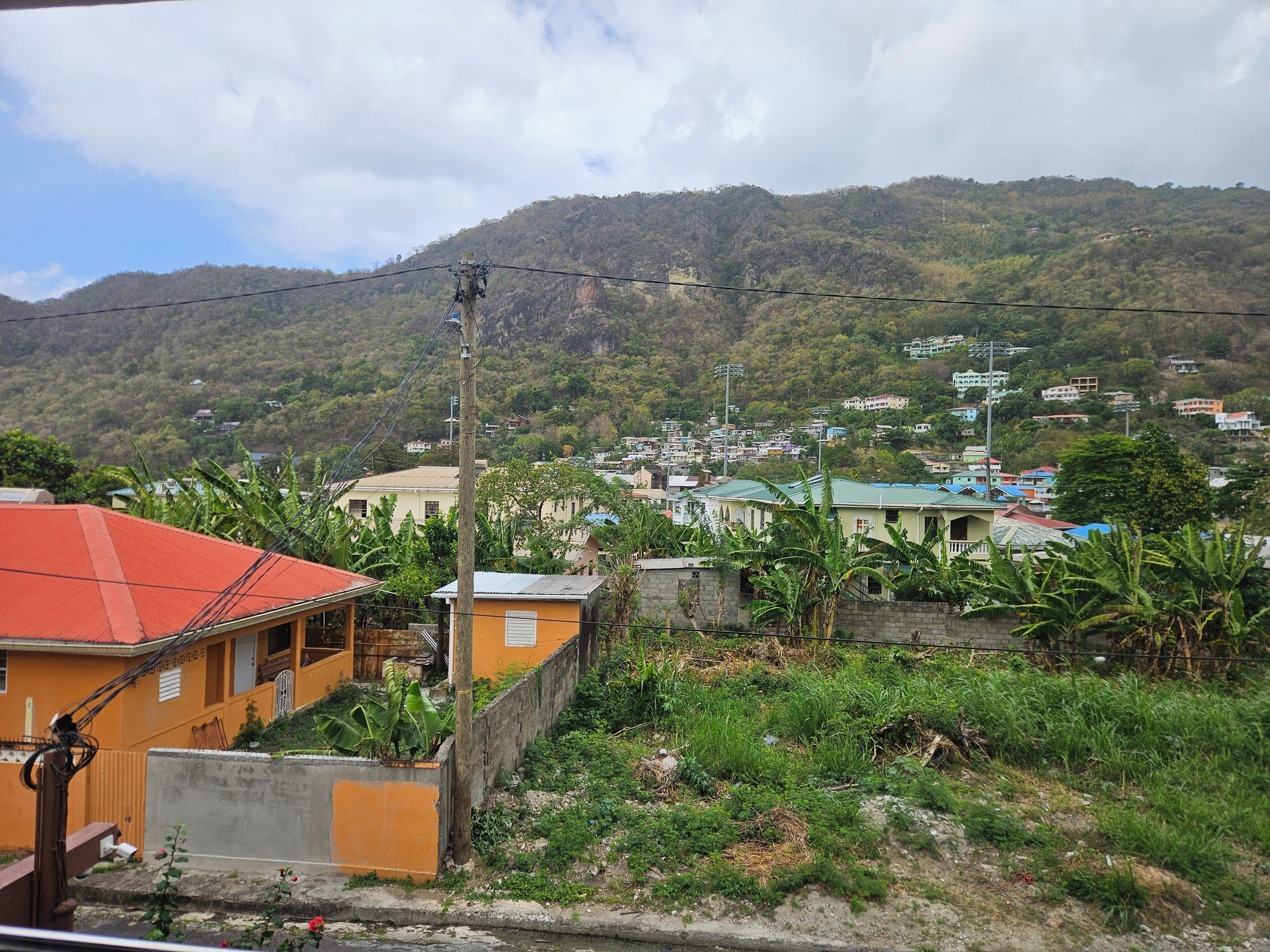 A residential area with houses, a hill in the background, and a power line.