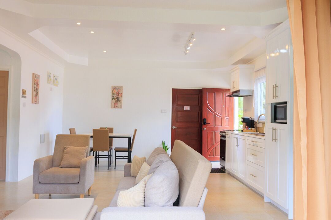 Una sala moderna con sofá, sillón y comedor.