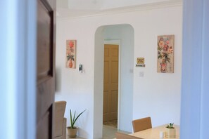 A dining area with a table, chairs, and a potted plant.