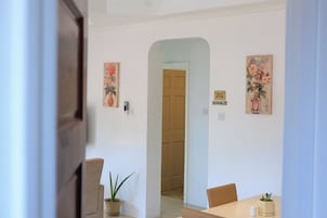 Un comedor con una mesa, sillas y una planta en maceta.