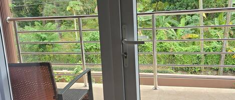 A view from inside a room through a glass door, with a sign instructing to lock the door, pull up the handle, and turn the key to the left.