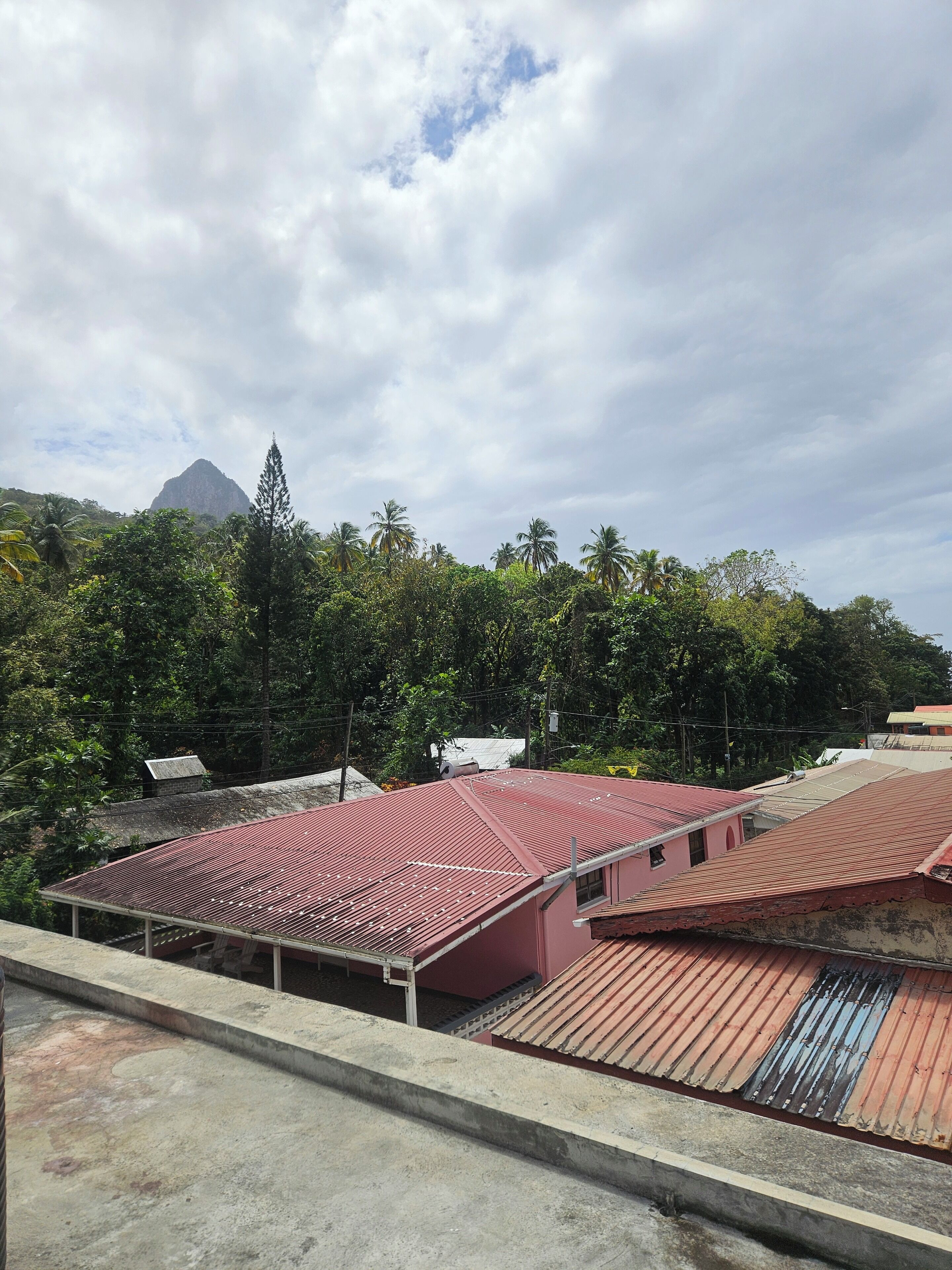 Un bâtiment avec un toit rouge et une vue sur une montagne en arrière-plan.