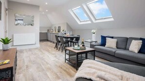 A modern loft apartment with a dining area, a sofa, and skylights. - SOBO Loft Southborne Grove +Beach Deluxe Apartment (Southbourne)