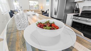 Una cocina moderna con una isla de madera, electrodomésticos de acero inoxidable y un cuenco de fruta sobre la isla.