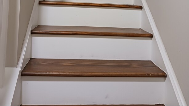 Un escalier avec des marches en bois et une rampe en bois.