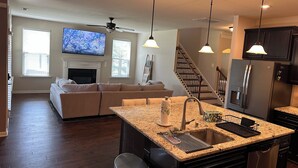 A modern kitchen with granite countertops, a stainless steel refrigerator, and a built-in dishwasher. - Spacious LUXE Home in RTP / near Airport (Durham)