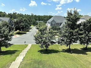 A residential street with houses, a sidewalk, and trees.