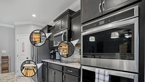 Una cucina moderna con elettrodomestici in acciaio inox, mobili scuri e un piano di lavoro in marmo.