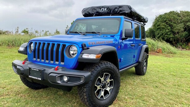A blue off-road vehicle with a roof rack and a license plate that reads "CUTTERAUTO.COM". - Camper Special Jeep Wrangler Rubicon 2021 (Anahola)