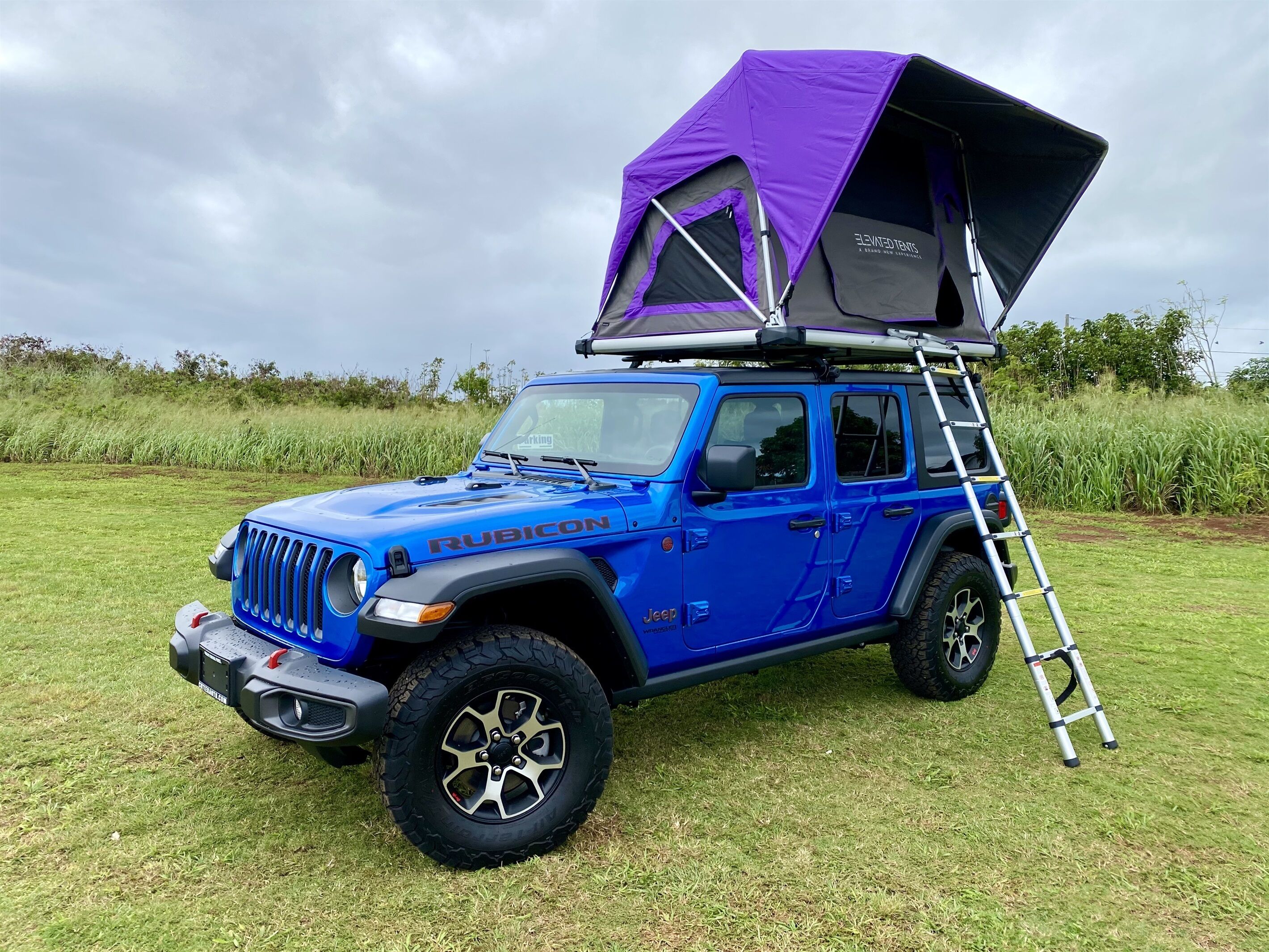 Sininen Jeep Rubicon -malli, jonka päällä on violetti teltta.