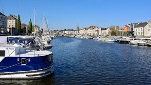 A marina with boats docked along a river, surrounded by buildings and trees. - GITE BROCELIANDE - CARENTOIR (CARENTOIR)