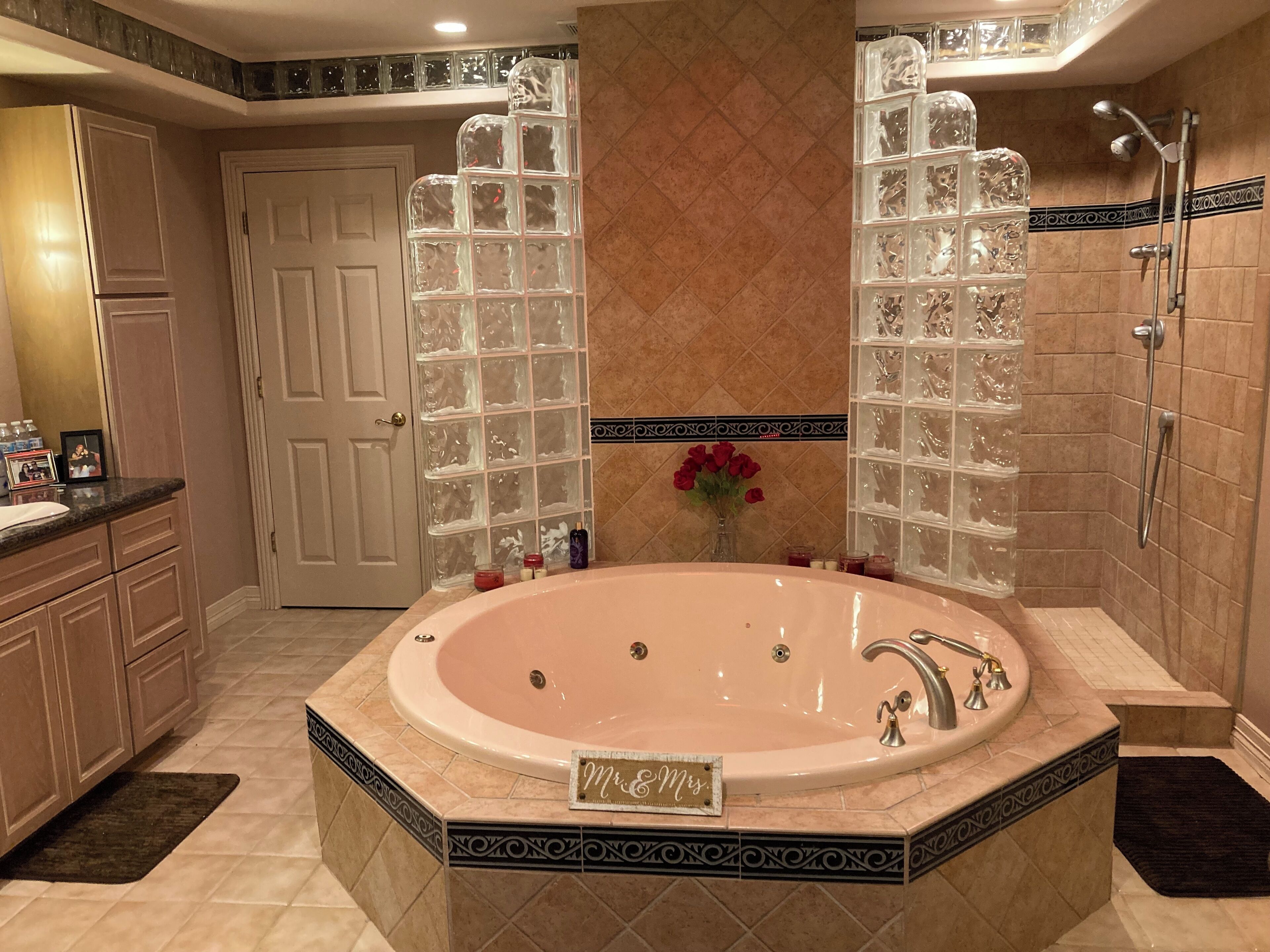 Une salle de bain spacieuse dotée d’une grande baignoire îlot, d’un espace douche et d’un meuble-lavabo avec un évier.