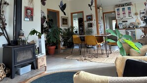 Un salon avec une cheminée, un coin repas et une cuisine.