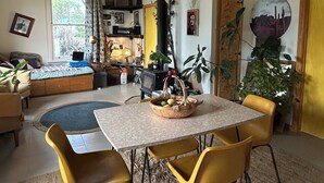 Un salon chaleureux avec un coin repas, comprenant une table avec des chaises, une cheminée et divers éléments de décoration.