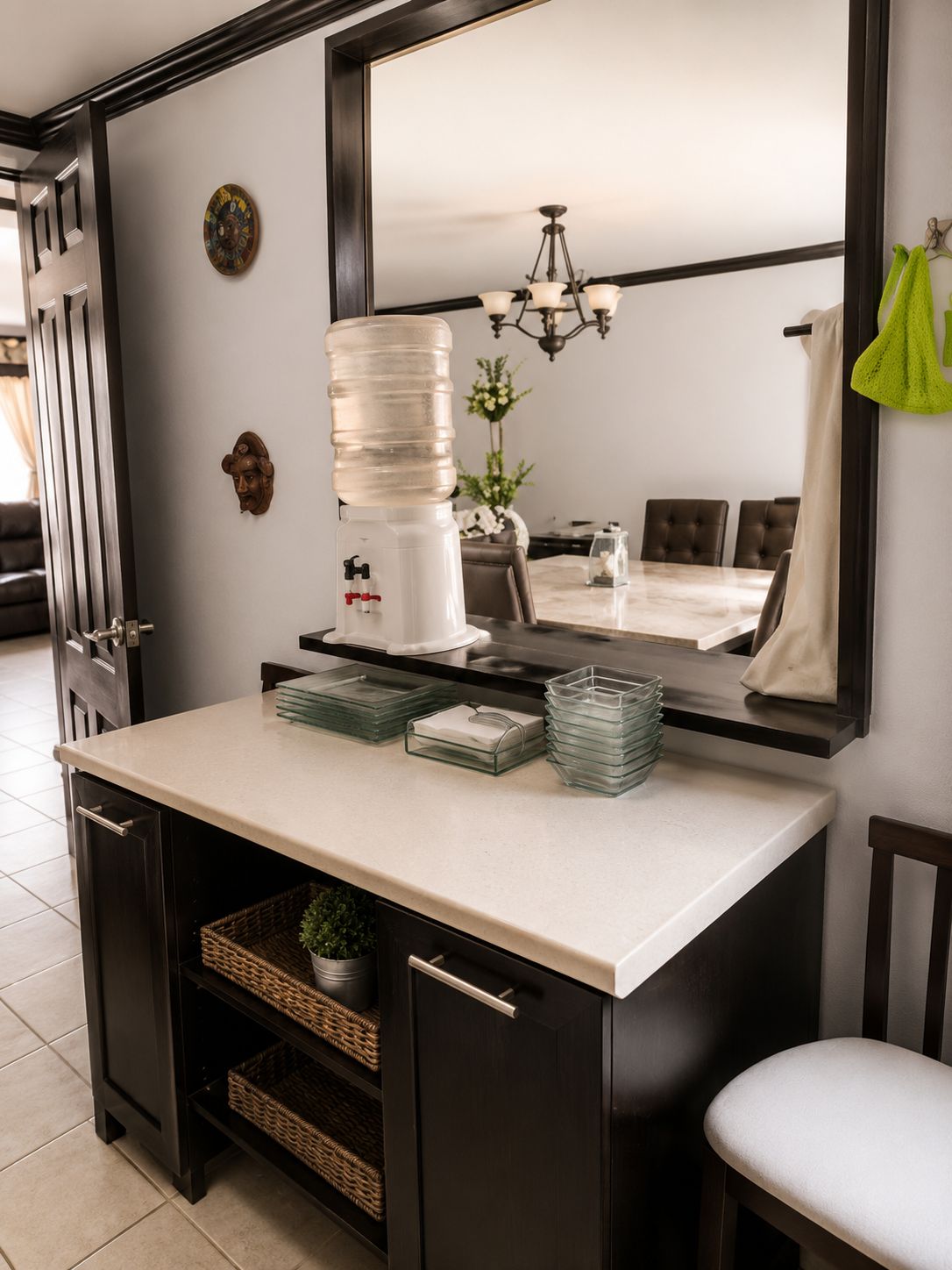 A compact kitchen with a built-in refrigerator, a sink, and a dining area with a chandelier.