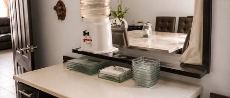 A compact kitchen with a built-in refrigerator, a sink, and a dining area with a chandelier.