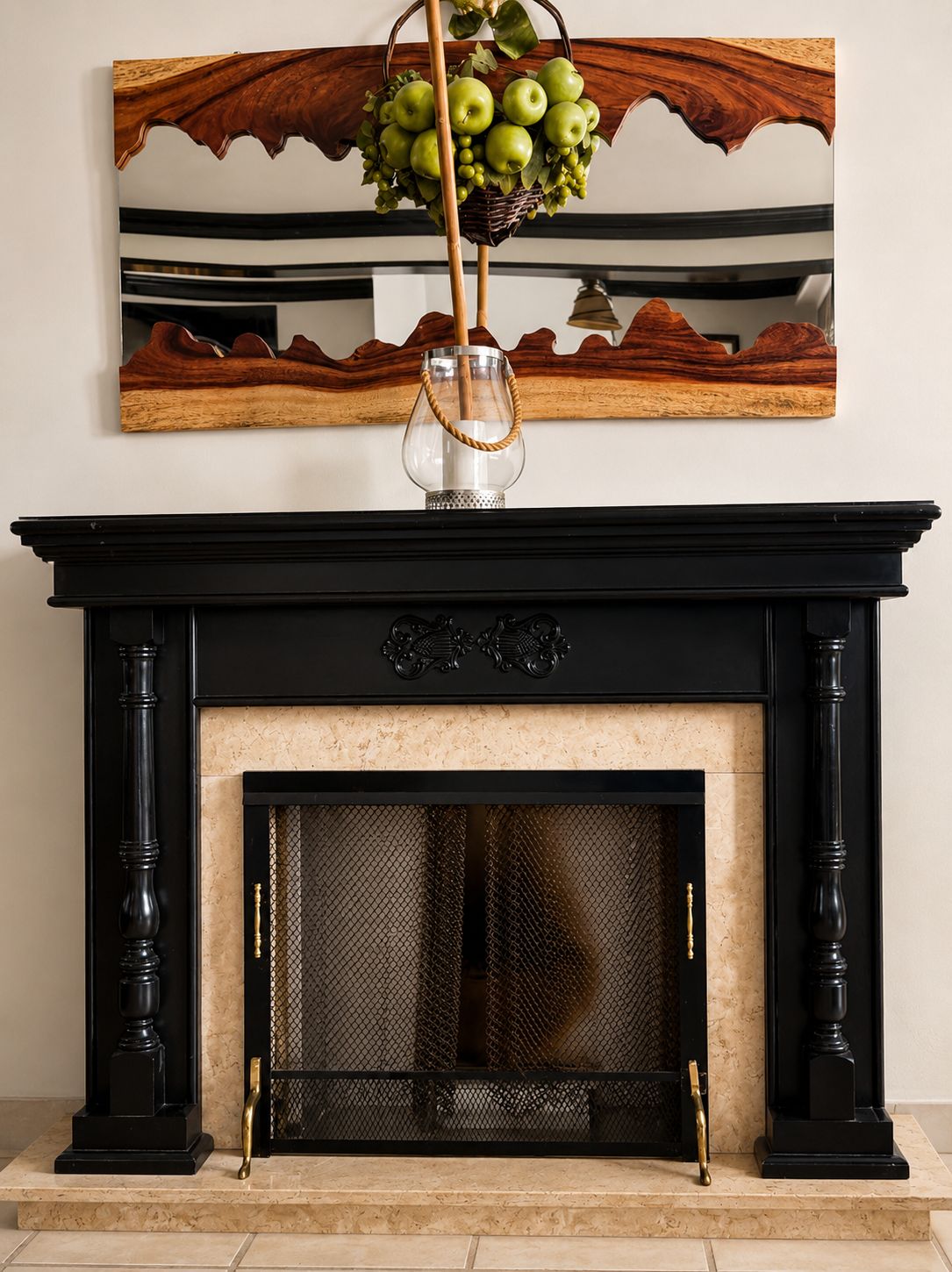 A fireplace with a black mantel and a decorative piece above it.