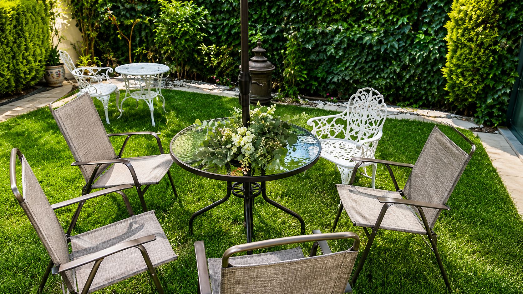 A patio with a round table, four chairs, and a potted plant.