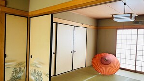 Una habitación japonesa tradicional con suelo de tatami, puertas correderas y un celosía de papel.