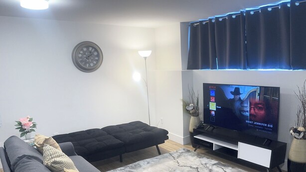 Una sala de estar moderna con un sofá modular, un televisor de pantalla plana y una alfombra decorativa.
