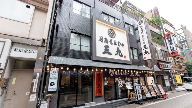 Un immeuble avec un restaurant au rez-de-chaussée, une enseigne avec des caractères japonais et une enseigne d’hôtel au-dessus de l’entrée.