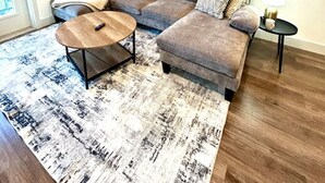 Una sala de estar moderna con un sofá modular, una mesa de centro y una alfombra.