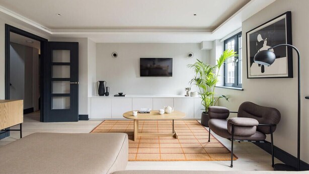 A modern living room with a sofa, a coffee table, a chair, a TV, and a plant. - The Covent Garden Maison — 4‑Bed Duplex Sleeps 8 (London)