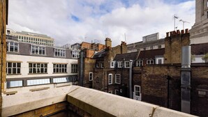 A view of a narrow street with terraced houses, a mix of brick and white facades, and a clear sky. - The Covent Garden Maison — 4‑Bed Duplex Sleeps 8 (London)