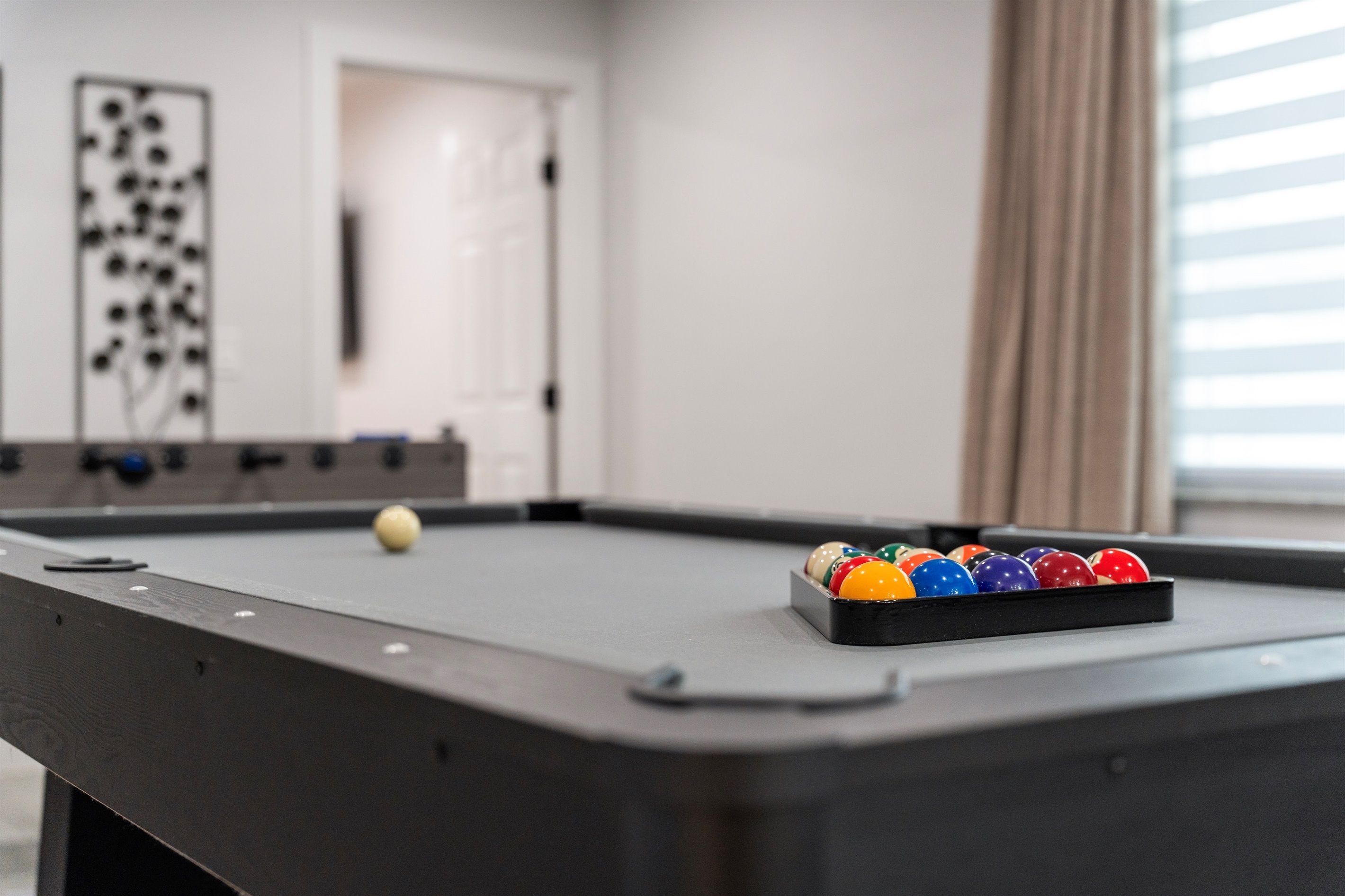 A pool table with a set of balls and a cue stick.