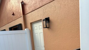 Um quarto com uma porta branca, cerca branca e radiador cinzento.