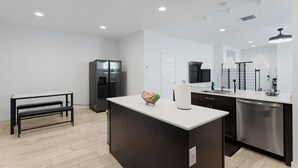 A modern kitchen with a central island, built-in appliances, and ample lighting. - Modern Desert Home–Great for Families & Groups, Near Golf, Hiking & City Fun (Phoenix)