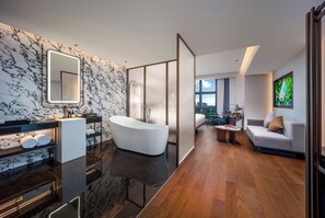 Un baño moderno con una bañera independiente, un espejo grande y un salpicadero de mármol.