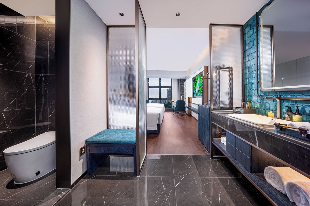 A modern bathroom with a toilet, bidet, and a large mirror.