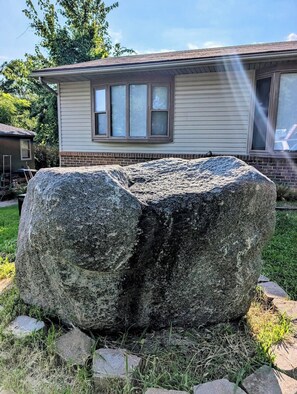 A large rock in front of a house with a window and a garage. - 5 bedrooms 2 baths walking distance to State Fair (Des Moines)
