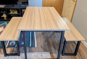 A rectangular wooden table with black metal legs, placed on a patterned rug. - 5 bedrooms 2 baths walking distance to State Fair (Des Moines)