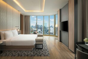 Une chambre d’hôtel moderne avec un grand lit, un bureau et une télévision.