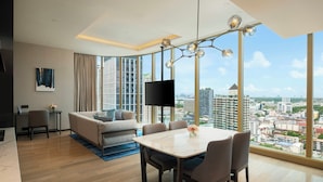 Une chambre d’hôtel moderne offrant une vue imprenable sur la ville, un coin repas et un téléviseur à écran plat.