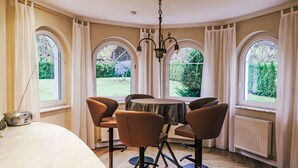 Un coin repas avec une table ronde, quatre chaises et un lustre.