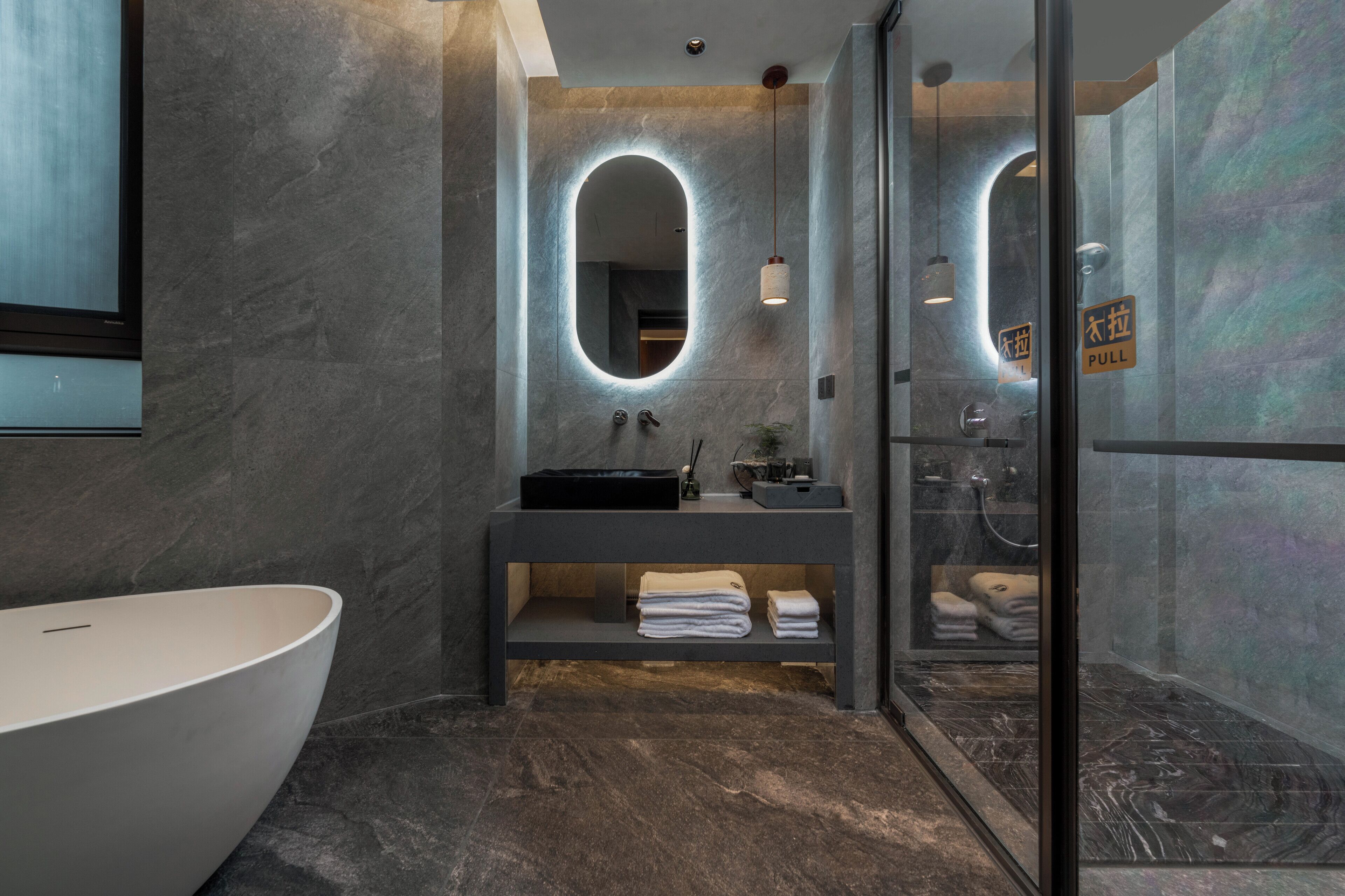 Une salle de bain moderne avec une baignoire sur pieds, un meuble-lavabo avec miroir et une douche à l’italienne.